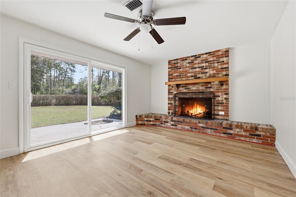 129 Southwest Benz Way Lake City, FL 32024 - Photo 11 of 30 a view of an empty room with wooden floor fireplace and a window