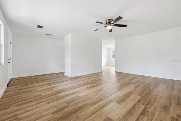 an empty room with fan and windows