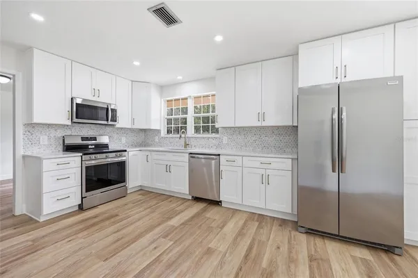 a kitchen with stainless steel appliances a refrigerator sink and cabinets