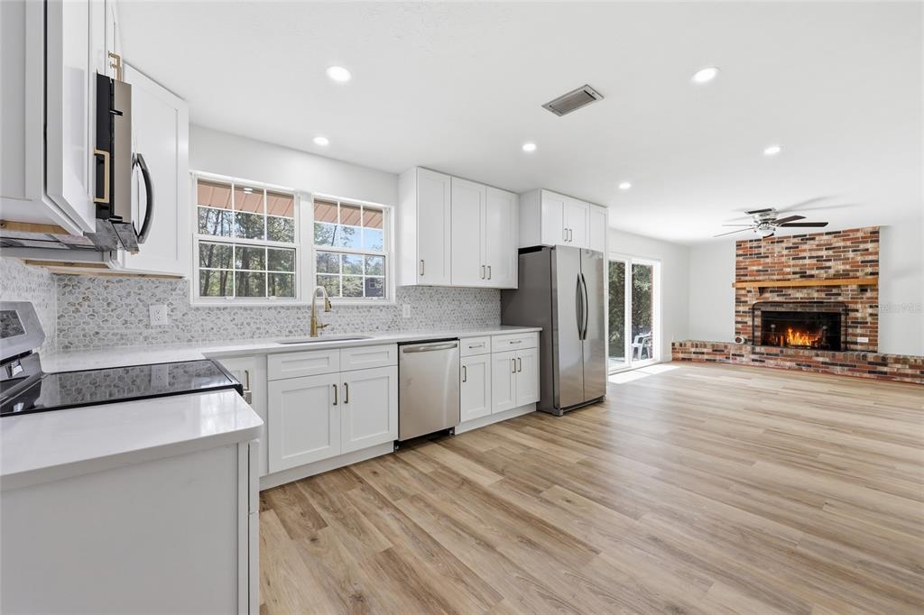 129 Southwest Benz Way Lake City, FL 32024 - Photo 10 of 30 a kitchen with stainless steel appliances a refrigerator sink and cabinets