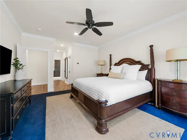 a bedroom with a bed and dresser with wooden floor