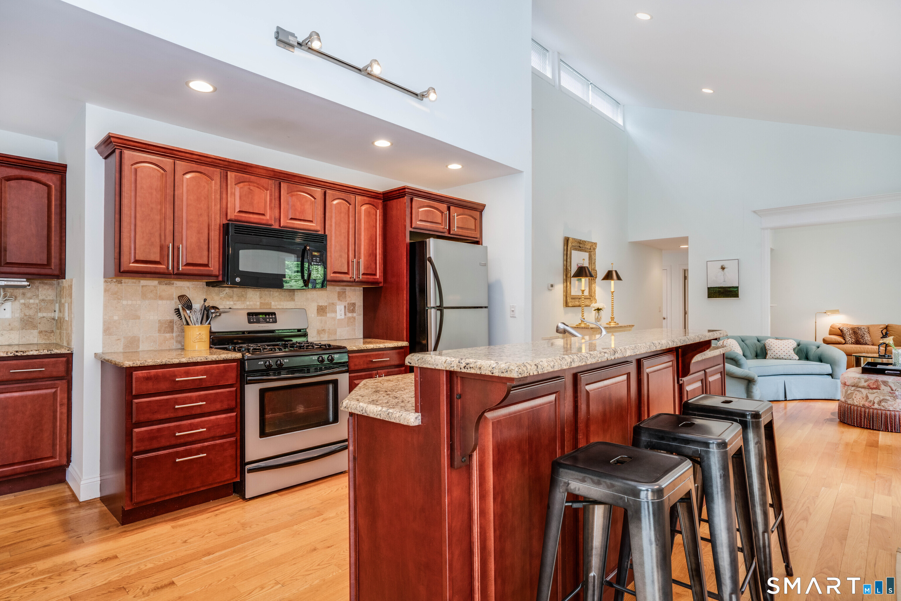 3 Morgan Place, Unit 3 Avon, CT 06001 - Photo 8 of 29 a large kitchen with stainless steel appliances granite countertop a stove top oven a sink dishwasher a dining table and chairs with wooden floor