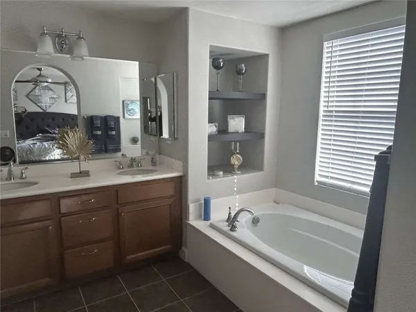 a spacious bathroom with a bathtub sink and mirror