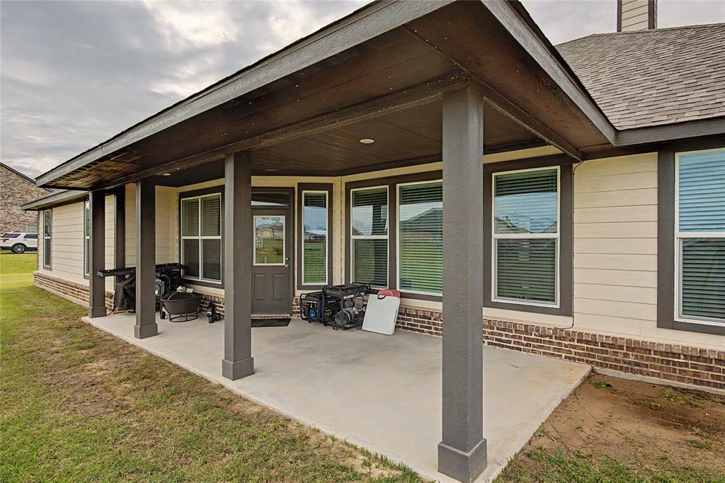 185 Chester Road Springtown, TX 76082 - Photo 38 of 40 Covered patio with a concrete slab, supported by four square columns