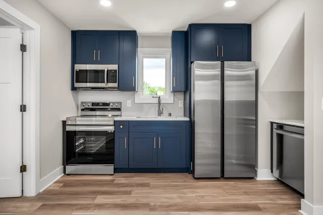 a kitchen with stainless steel appliances granite countertop a refrigerator stove and sink