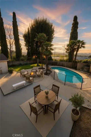 a view of a swimming pool with a patio and a yard
