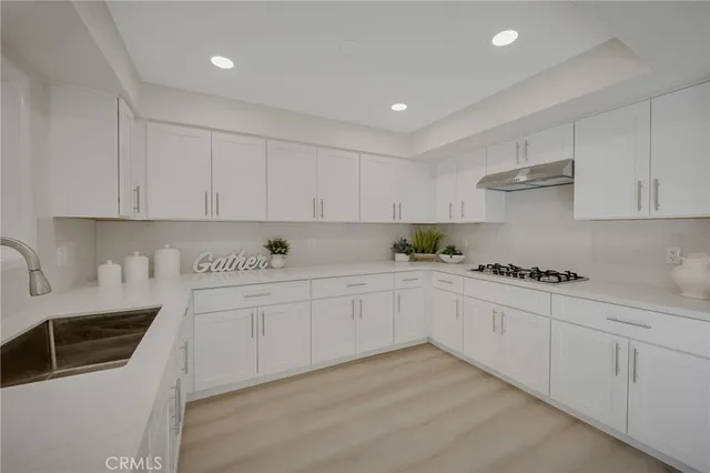 a kitchen with granite countertop white cabinets and white appliances