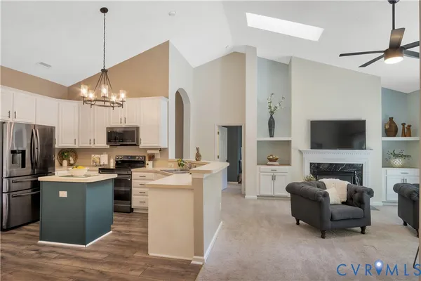 a living room with stainless steel appliances furniture and a flat screen tv