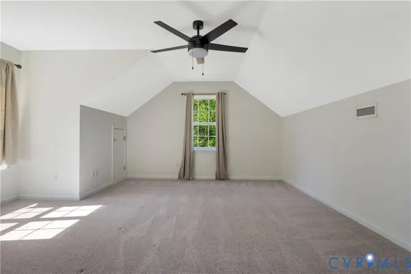 an empty room with windows and ceiling fan