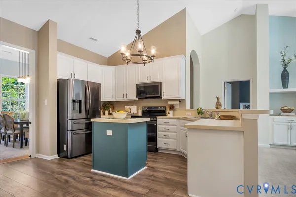 a kitchen with kitchen island a sink stove and refrigerator