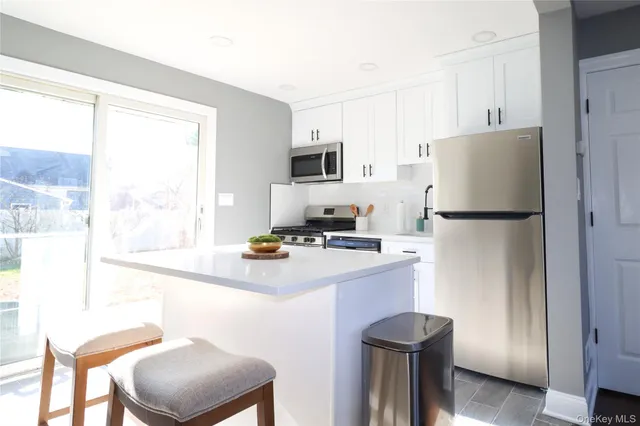a kitchen with a refrigerator a stove and a window