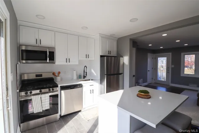 a kitchen with stainless steel appliances a stove refrigerator sink and cabinets