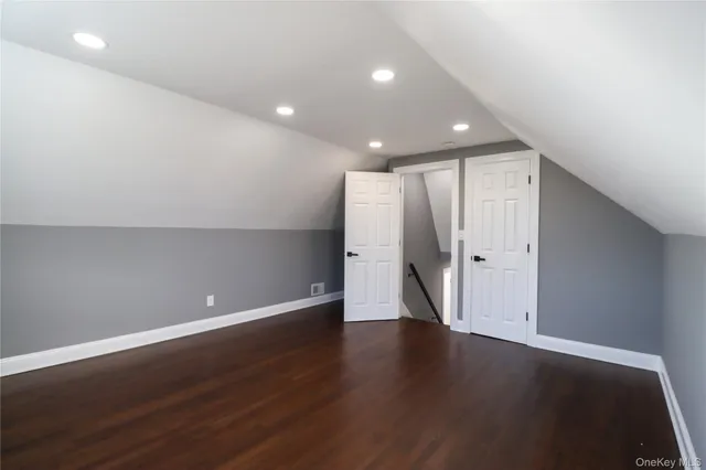 a view of an empty room with wooden floor and closet