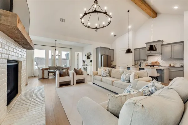 a living room with furniture kitchen view and a chandelier