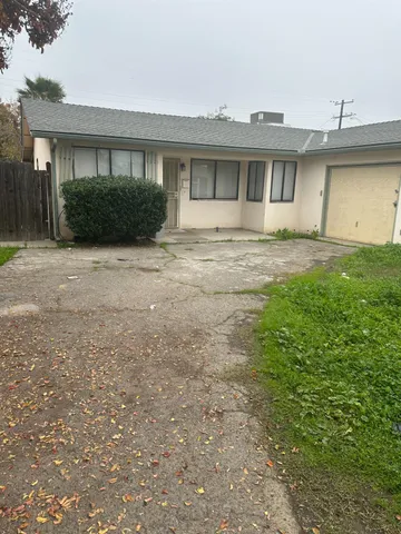 a front view of a house with a yard and potted plants