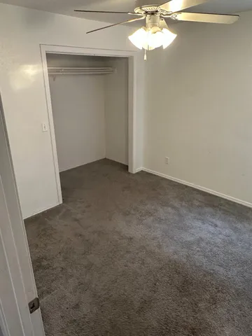 an empty room with a chandelier fan