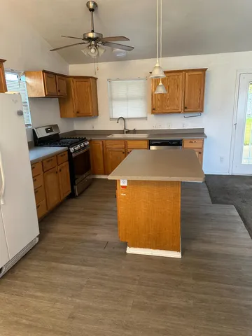 a kitchen with stainless steel appliances granite countertop a sink a stove top oven a counter space and cabinets