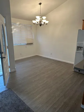 a view of a room with wooden floor and door