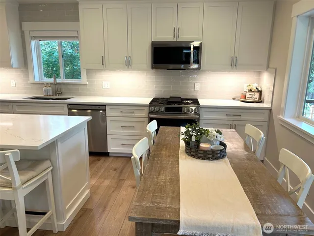 a kitchen with a sink a stove and cabinets