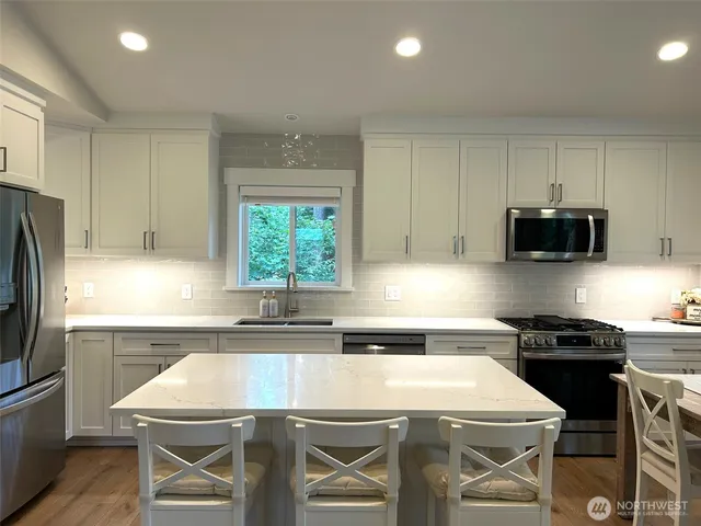 a kitchen with a stove a sink and a refrigerator