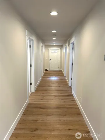 a view of a hallway with wooden floor