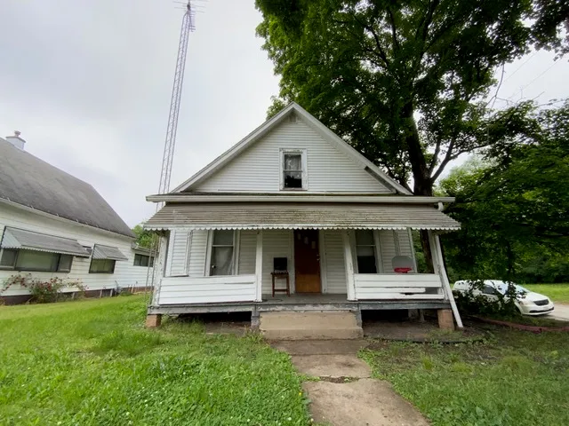 a white house covered with tall trees