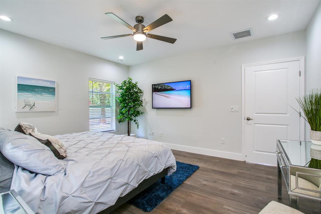 3040 Belcher Road Dunedin, FL 34698 - Photo 12 of 24 a bedroom with a large bed and a chandelier