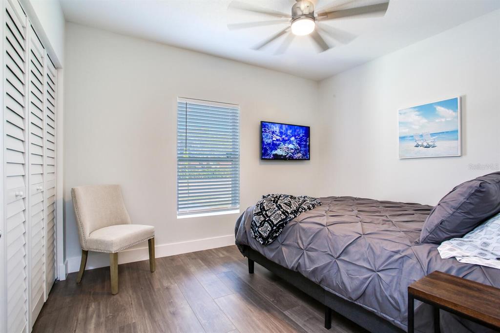 3040 Belcher Road Dunedin, FL 34698 - Photo 17 of 24 a bedroom with a bed and a chandelier