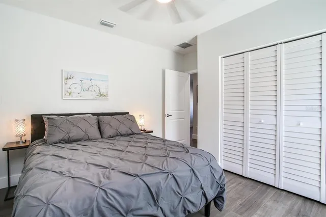 a large bed sitting in a bedroom and table next to a window