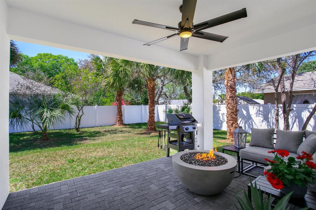 3040 Belcher Road Dunedin, FL 34698 - Photo 22 of 24 a backyard of a house with barbeque oven table and chairs
