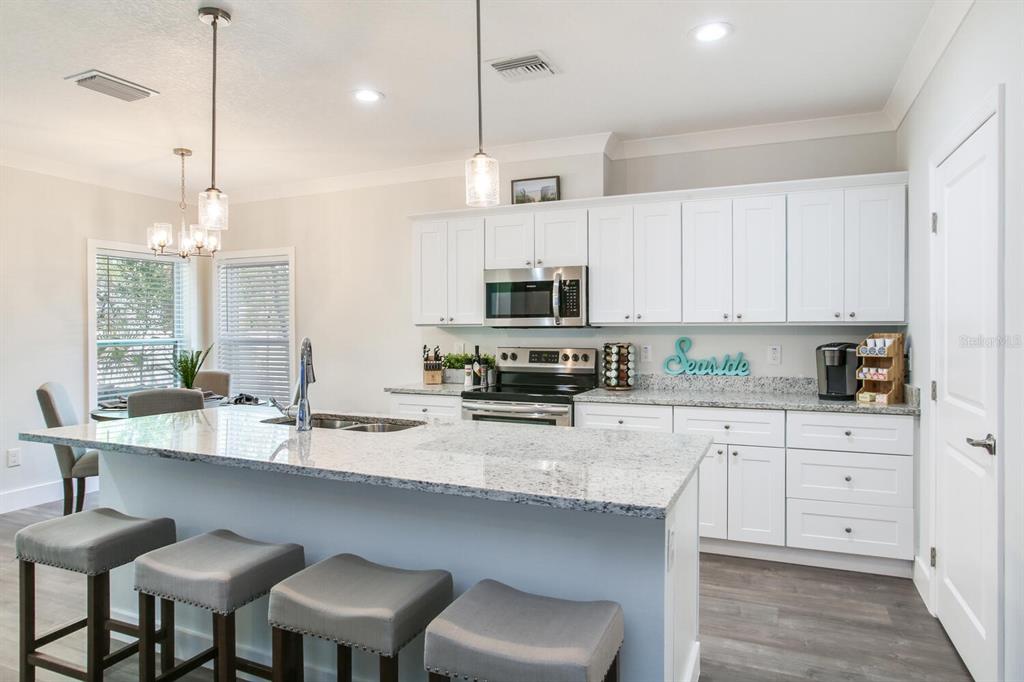 3040 Belcher Road Dunedin, FL 34698 - Photo 6 of 24 a large kitchen with granite countertop a sink a counter space appliances and cabinets