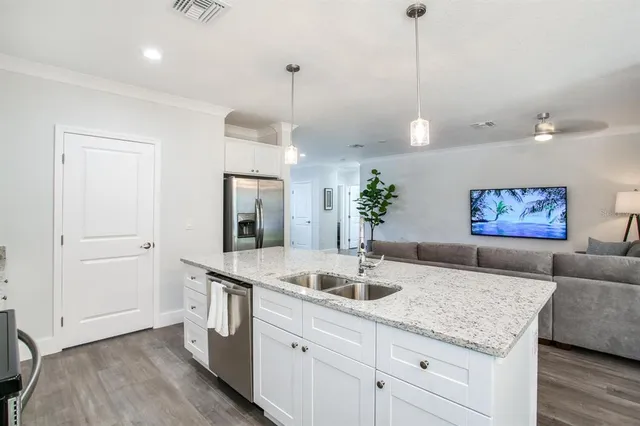 a living room with kitchen island a sink and wooden floor