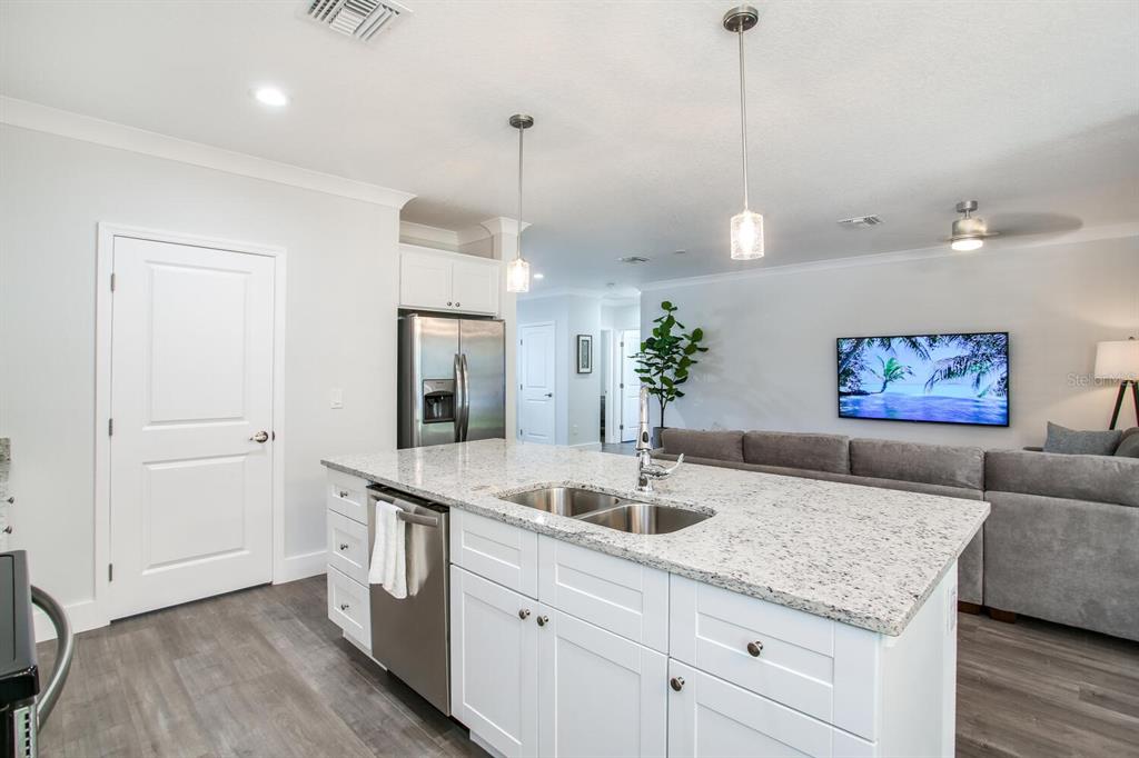 3040 Belcher Road Dunedin, FL 34698 - Photo 8 of 24 a living room with kitchen island a sink and wooden floor