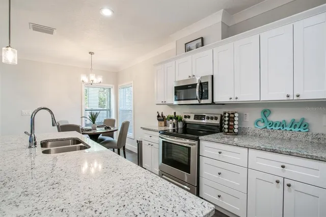 a kitchen with stainless steel appliances granite countertop a stove a sink a refrigerator a stove and cabinets