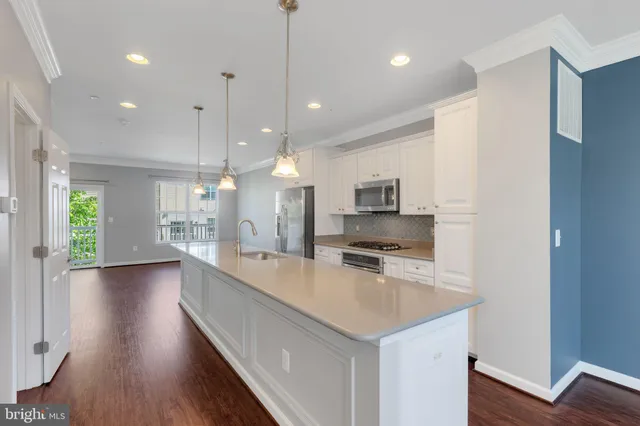a view of a big room with wooden floor and windows