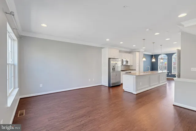 a open kitchen with white cabinets and chandelier