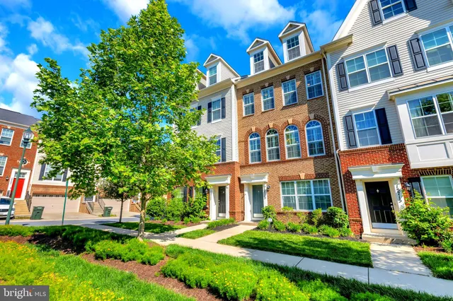 front view of a brick house with a yard plants