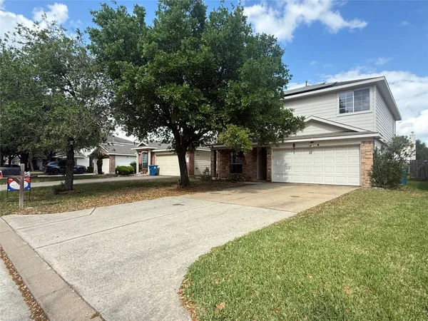 a front view of a house with a yard and a garage
