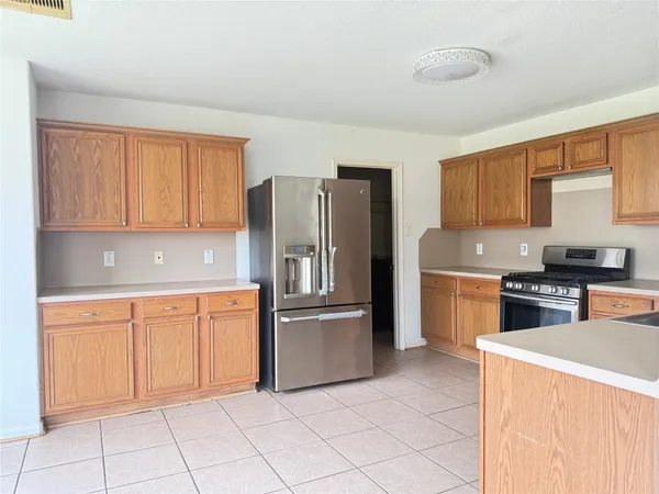 a kitchen with stainless steel appliances granite countertop a refrigerator sink and stove