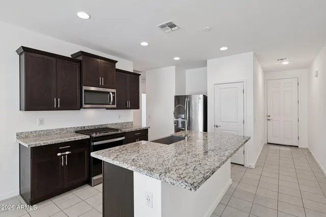 a kitchen with stainless steel appliances granite countertop a sink stove and refrigerator