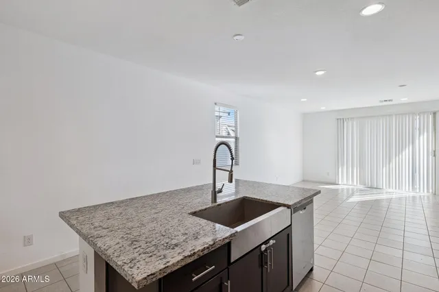 a kitchen with granite countertop a sink and a wooden floor