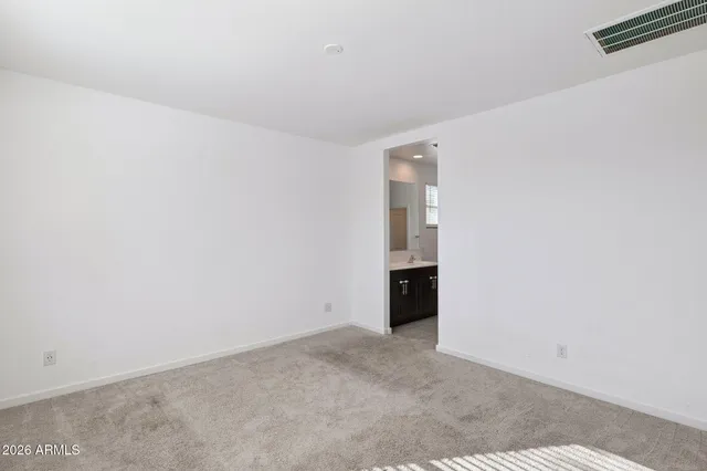 a view of an empty room and a kitchen