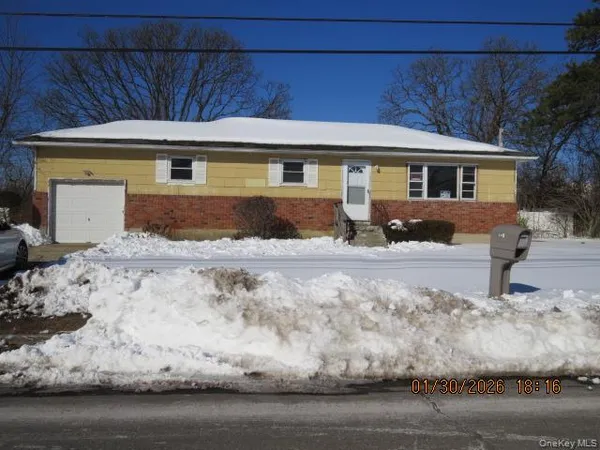 a front view of a house with a yard covered with snow