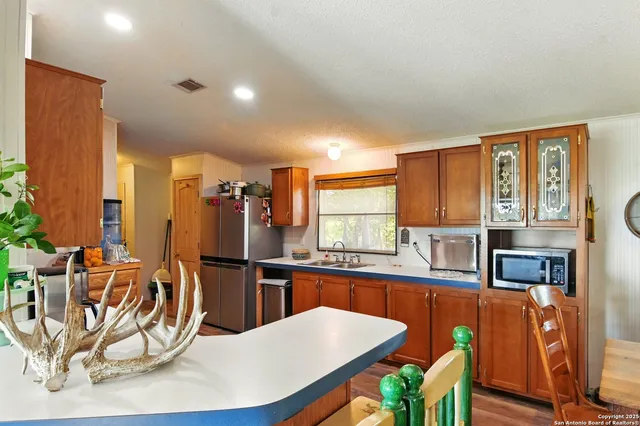 a kitchen with stainless steel appliances kitchen island granite countertop a refrigerator a stove a sink dishwasher with a dining table and chairs