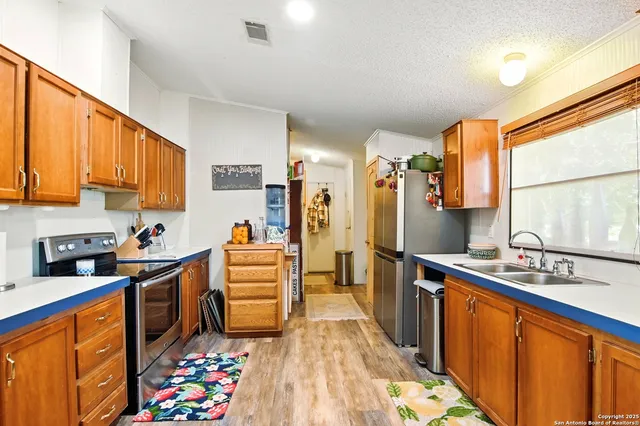 a kitchen with granite countertop stainless steel appliances a sink counter space and a window