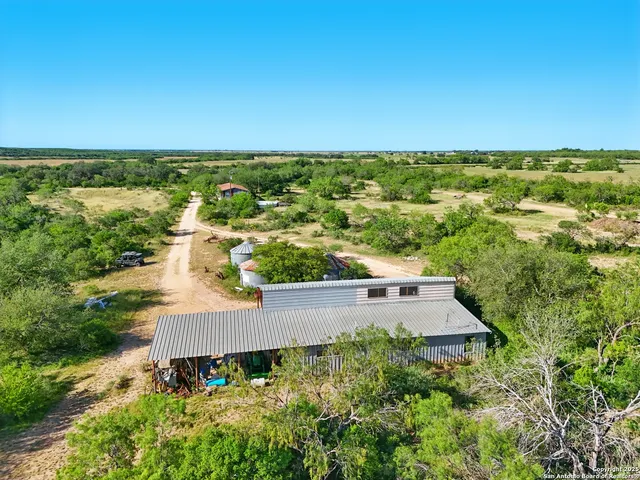 an aerial view of a house with a yard and lake view