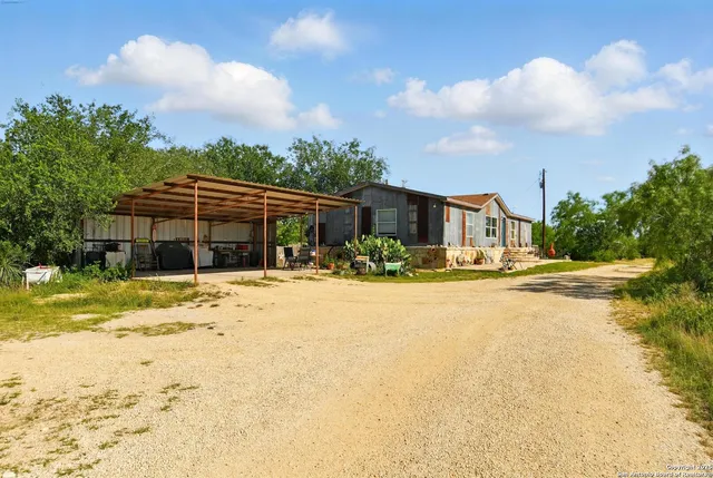 a view of a house with a yard and sitting area