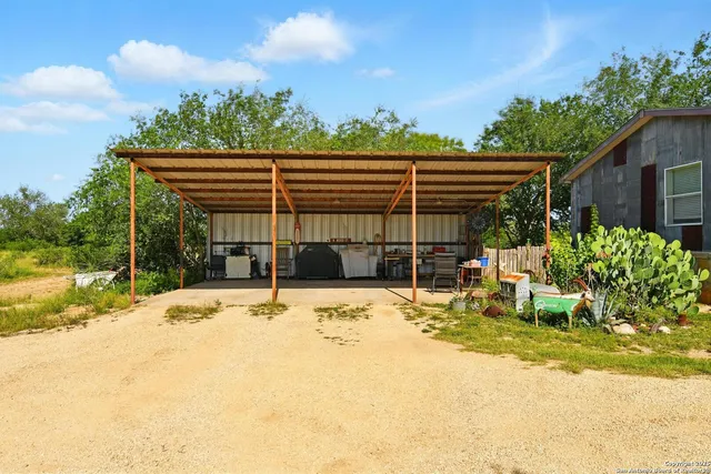 a backyard of a house with table and chairs with wooden fence
