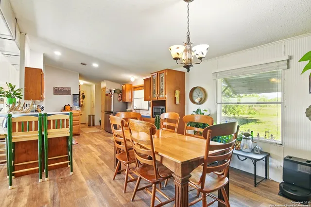 a dining room filled chandelier and wooden floor