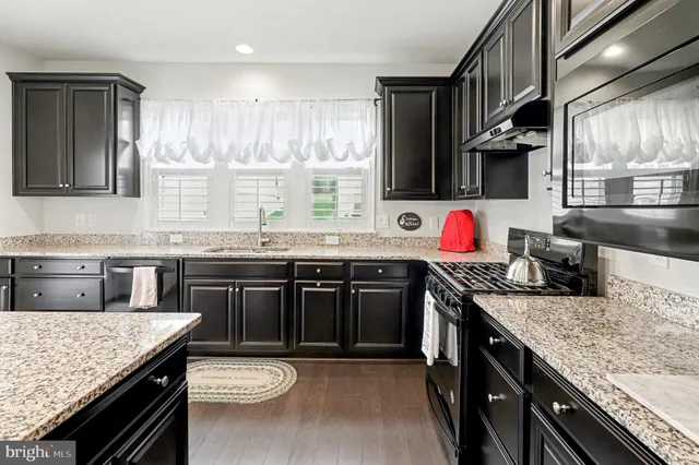 a kitchen with granite countertop a sink and a stove